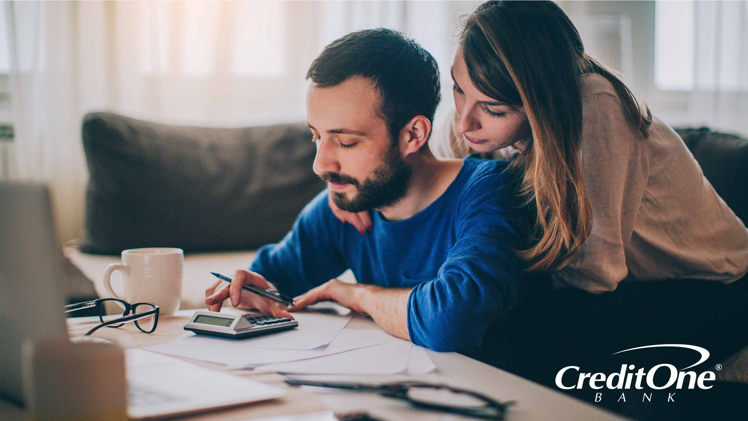 Couple at kitchen table calculating their debt